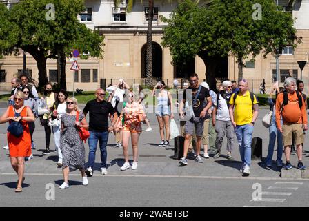 Barcelona, Spain - May 26, 2022: People in full sun begin to cross the pedestrian crossing on a busy avenue in the city center Stock Photo