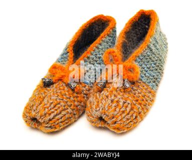 Colorful handmade knitted made in wool slippers stand on a white background Stock Photo