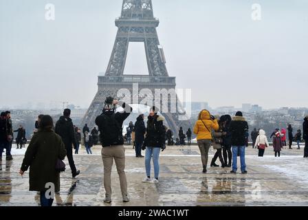 Unexpected snow in Paris. At Trocadéro Square, many tourists take souvenir photos with the Eiffel Tower in the background. Stock Photo