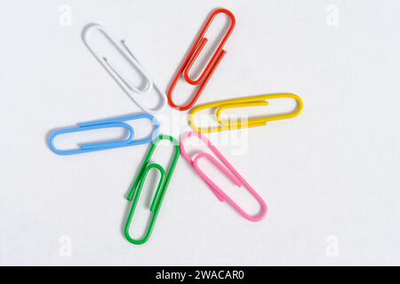 Multi colored paper clips are folded in shape star white background Stock Photo