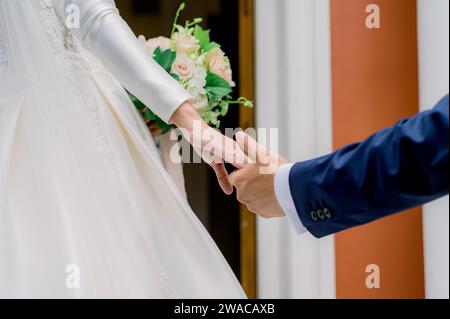 Crop newlyweds holding hands during wedding Stock Photo