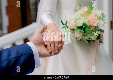 Crop newlyweds holding hands during wedding Stock Photo