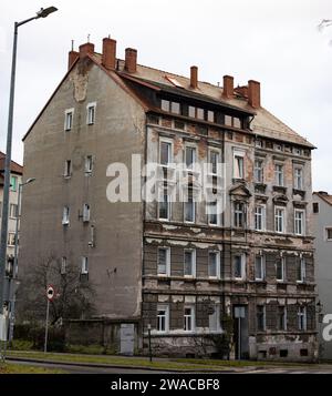Unrenovated old building in Zgorzelec, Poland. The facade is weathered and the plaster parts are broken out. The exterior is in a bad condition. Stock Photo