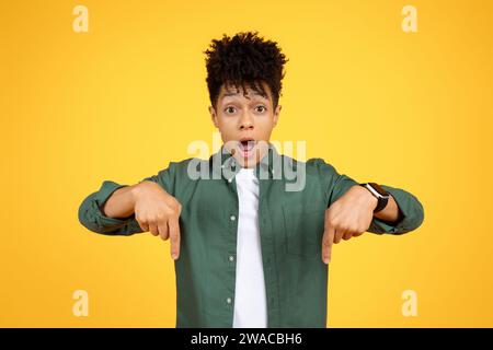 Shocked young african american man pointing down Stock Photo