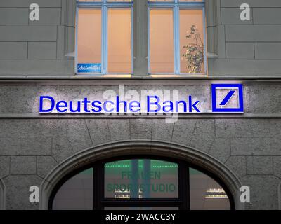 Deutsche Bank logo sign illuminated on a building exterior. The big German banking institution is systemically relevant. The business has branches. Stock Photo