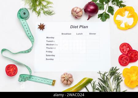 Diet food. Sheet of paper with diet plan for week. Pen and measuring tape on table. White background. Flat lay Stock Photo