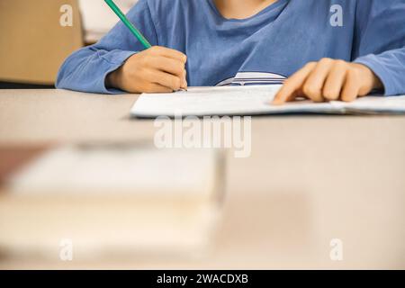 Caucasian elementary school child doing homework at the end of the school day. Close up and copy space. Stock Photo