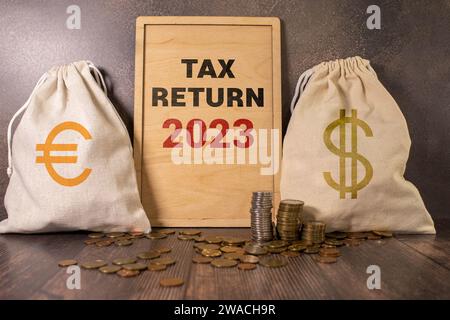Tax text in wooden cubes and tax or vat form documents to complete Individual income tax return form for payment to Government. Calculation tax return Stock Photo