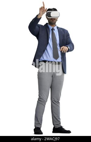 A man in an office suit on a White background listens to music on headphones Stock Photo