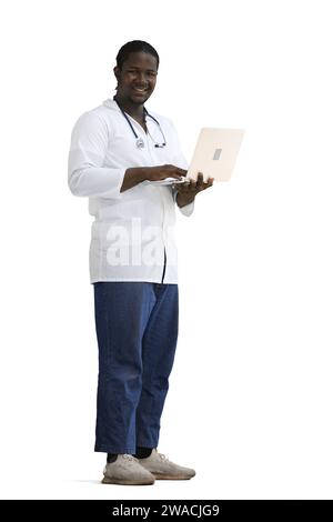 Full-length male doctor typing on a laptop on a White background Stock Photo