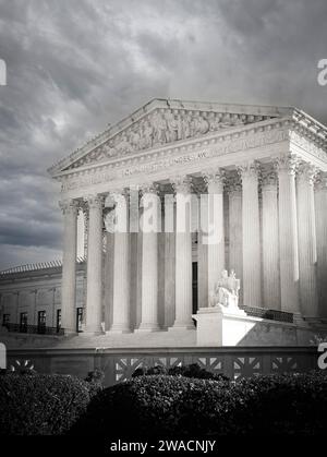 A cloudy and dramatic sky makes the US Supreme Court Building's neoclassical architecture highlight the seated white marble statue, the 'Guardian', DC Stock Photo