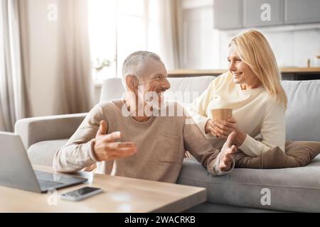 Cheerful senior couple using computer at home Stock Photo