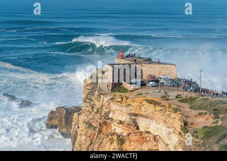 Waves breaking near the Fort of Sao Miguel Arcanjo Lighthouse in Nazare, Portugal, famously known to surfers for having the biggest waves in the world. Stock Photo