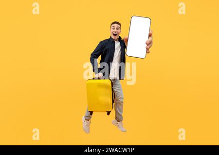 Tourism and holiday trip concept, guy showing phone, holding suitcase Stock Photo