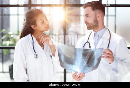 Two busy doctors working with papers and xray images Stock Photo