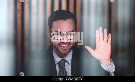 Young handsome businessman goodbye to the client and waves his hand. Stock Photo