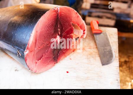 Venice Italy - May 10 2011;  Fish on display in Rialto night market famous for produce and good prices big tuna slab on chopping table with fish knife Stock Photo