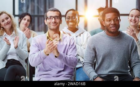 Happy multiethnic employees having fun while discussing project, sharing ideas, informal brainstorming sitting on chairs Stock Photo