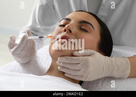 Doctor giving facial injection to young woman in clinic. Cosmetic surgery Stock Photo