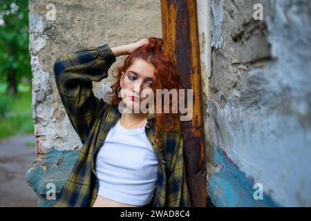 Portrait of thoughtful woman leaning on building wall Stock Photo