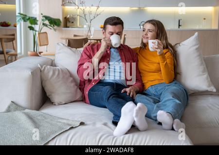 Loving young married couple spending weekend at home, enjoying tea drinking, speaking, doing nothing Stock Photo