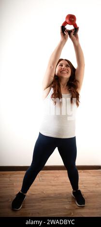 redhead woman doing exercises with a kettlebell Stock Photo