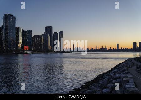 Manhattan, US, 02/01/2024, The general view of Manhattan and Long Island City from Roosevelt Island. Roosevelt Island, nestled in the East River between the boroughs of Manhattan and Queens in New York City, offers a unique blend of tranquility and urban living. Accessible by tram, subway, or bridge, this narrow island boasts a serene atmosphere distinct from the bustling city nearby. Home to a diverse community, it features a mix of residential complexes, parks, and historic landmarks like the renovated Blackwell House. Visitors and residents enjoy scenic waterfront views, tree-lined pathways Stock Photo