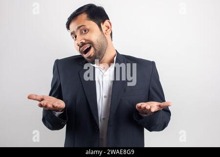 A smartly-dressed man in a suit is gesturing with his hands while smiling broadly Stock Photo