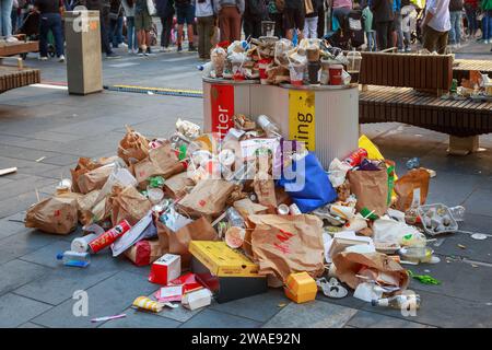 Overflowing rubbish and recycling bins surrounded with fast food and drink containers. Auckland, New Zealand Stock Photo