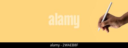 Black male hand drawing with an smart pencill on yellow banner, copy space. Stock Photo