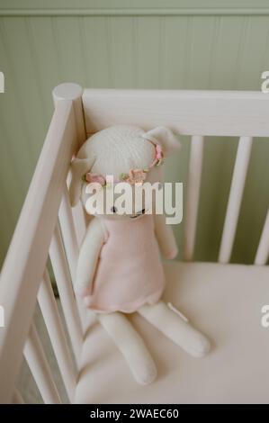 A vertical closeup shot of a cute pink plush toy in a baby crib Stock Photo