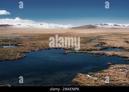 A picturesque landscape featuring a tranquil body of water with snow-capped mountains. Stock Photo