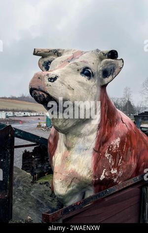 A vertical closeup of a cow sculpture on a cloudy day Stock Photo