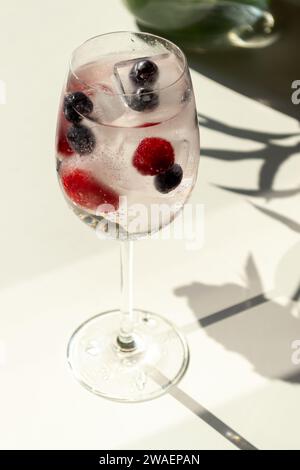 Glass of mineral water with ice cubes on white table Stock Photo