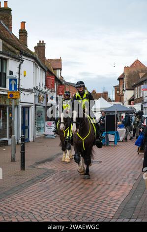 Thames Valley mounted police officers on patrol ride through Chesham town centre High Street. Buckinghamshire, England, UK Stock Photo