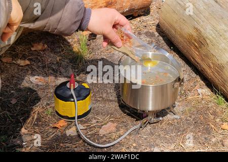 Traveler foods in outdoor activities. Food in bowler in the green forest. Camping food making. Stock Photo