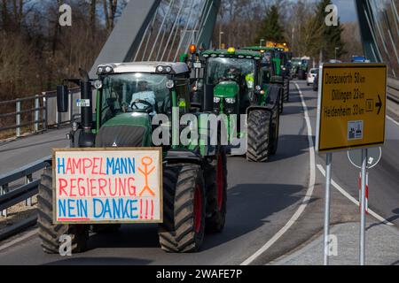 04 January 2024, Bavaria, Günzburg: Numerous tractors drive along the B16 federal highway to a farmers' association rally against the federal government's austerity plans. Several hundred farmers from northern Swabia and neighboring eastern Württemberg took part with their tractors. Photo: Stefan Puchner/dpa Stock Photo