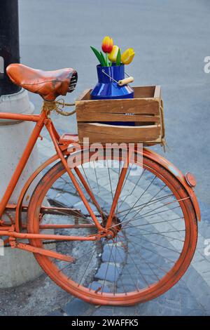 Basket with flowers on the trunk of an old Bicycle. Garden decor in Provence style Stock Photo