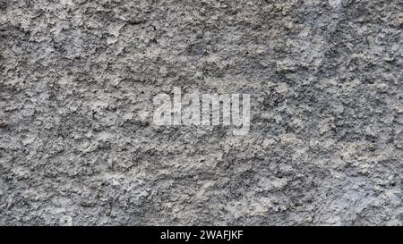 gray textured background with uneven surface of hardened concrete plaster, monochrome empty copy space with embossed texture of cement finish Stock Photo