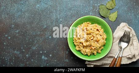 Ven Pongal (Khara Pongal), traditional Indian savoury rice dish made during celebrating Pongal festival, served in bowl top view on concrete rustic Stock Photo