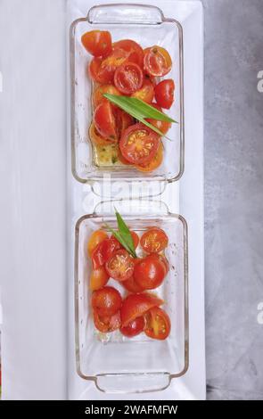 Delicious appetizer of cherry tomatoes in glass plates on a white background Stock Photo