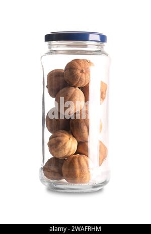 Whole dried limes, in a glass jar with lid. Loomi, black lime, noomi basra, or also limoo amani, strongly flavored, sun-dried fruits. Stock Photo