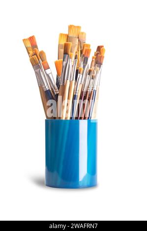 Paintbrushes in a blue plastic cup. Numerous used flat and round paintbrushes of various sizes, used by artists in one stroke painting. Stock Photo