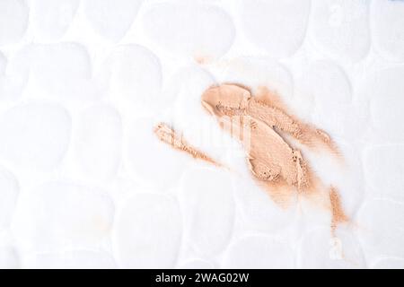 Foundation stains on the white upholstery of the couch or carpet. daily life stain and cleaning concept. top view Stock Photo