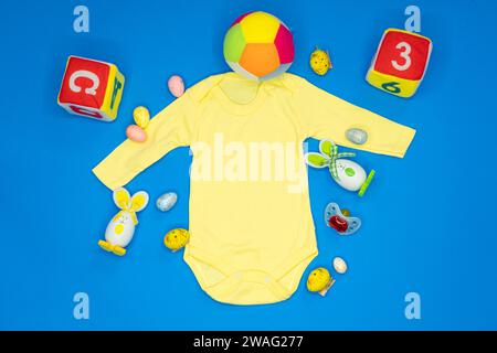 Baby onesie romper bodysuit product mockup. Christmas svg craft product mockup with Baby Pacifier, Teddy bears, socks and various toys on blue backgro Stock Photo