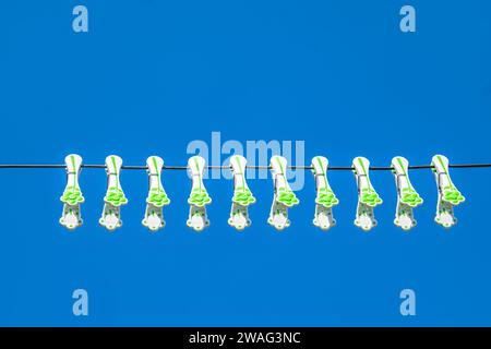 plastic laundry clothes hooks on the wire with blue sky Stock Photo