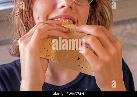 hands of a young girl take hard cheese, thinly sliced Stock Photo