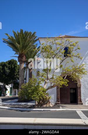 Park on Square of Help (Plaza de los Remedios) infront of a very well preserved historical church with. Bright blue sky. Yaiza, Lanzarote, Canary Isla Stock Photo