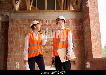 Manager and foreman using cellphone during construction object inspection Stock Photo
