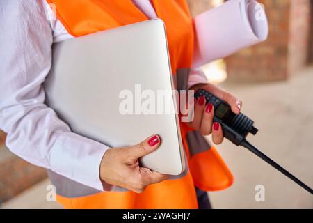 Building inspector using portable two-way radio and computer on site Stock Photo
